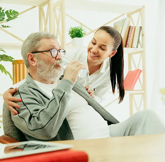 A woman is feeding an old man something