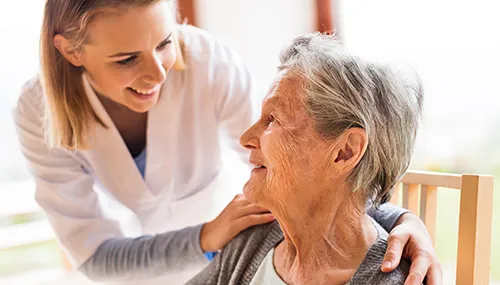 A nurse is caring for an elderly woman.