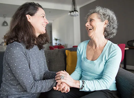 A woman and an older lady sitting on the couch