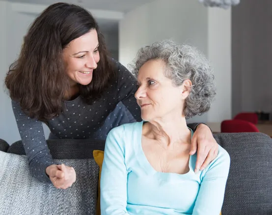 A woman sitting next to an older person.