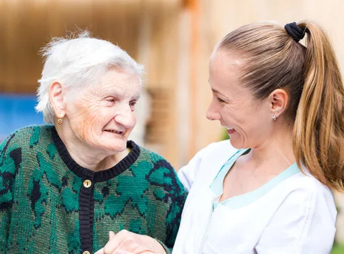 A woman and an old lady smiling for the camera.