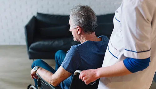 A man sitting in a chair with another person standing next to him.