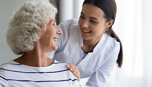 A woman and an older person smiling for the camera.