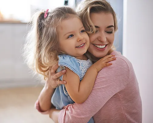 A woman holding a little girl in her arms.