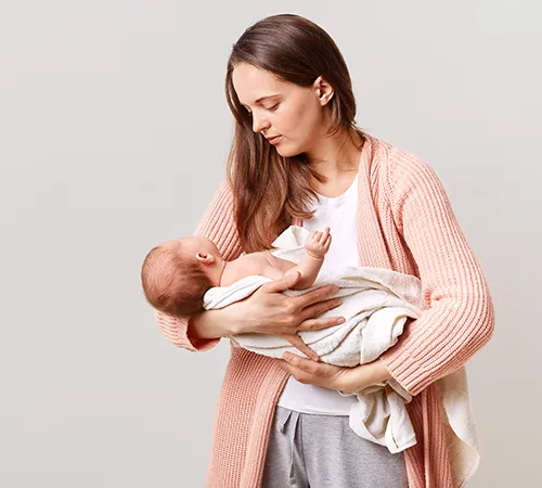 A woman holding a baby in her arms.