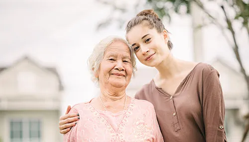 A woman and an old lady smiling for the camera.