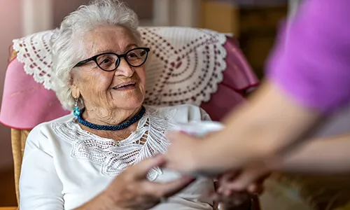 A woman is handing something to an older person.