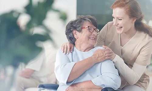 A woman and an elderly person are hugging.