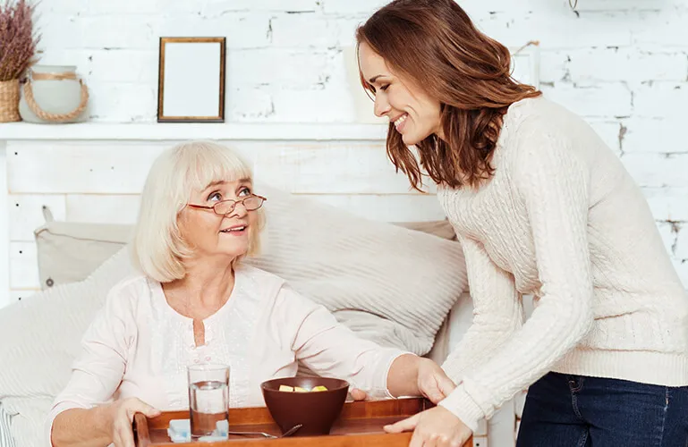 A woman and an older lady sitting at a table.