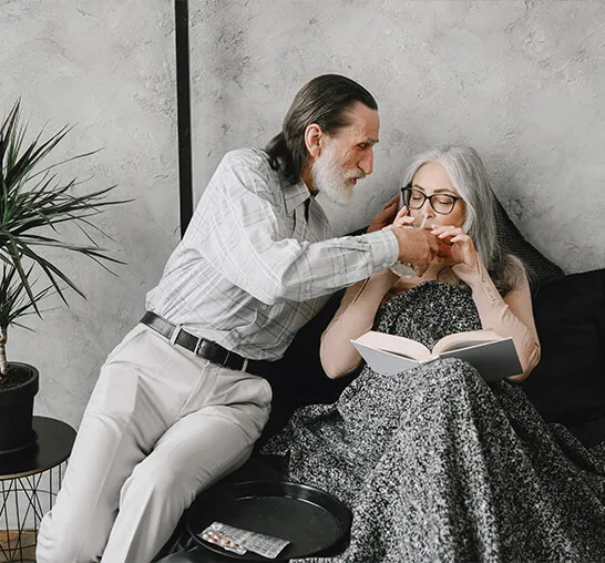 A man and woman sitting on the floor reading.