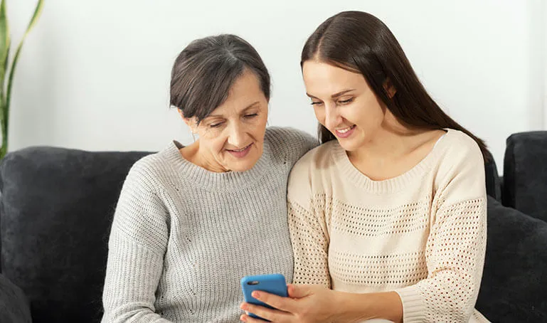 Two women looking at a phone together.