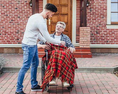 A man standing next to an older person.