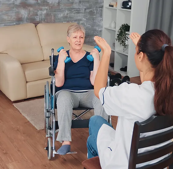 A woman in a wheelchair and another person holding something.