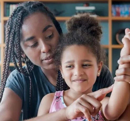 A woman and child are looking at something on the arm.