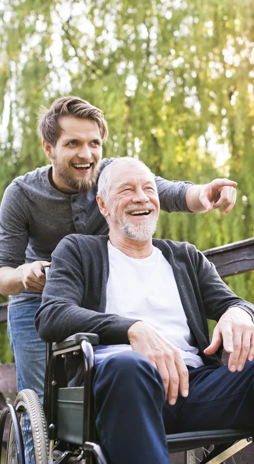 A man in a wheelchair and another man standing next to him.